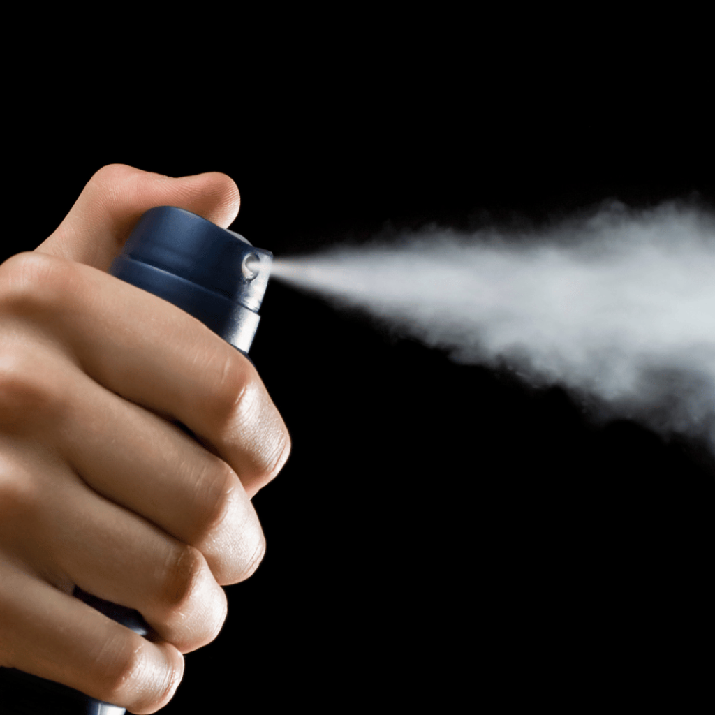 Hand spraying an aerosol bug spray