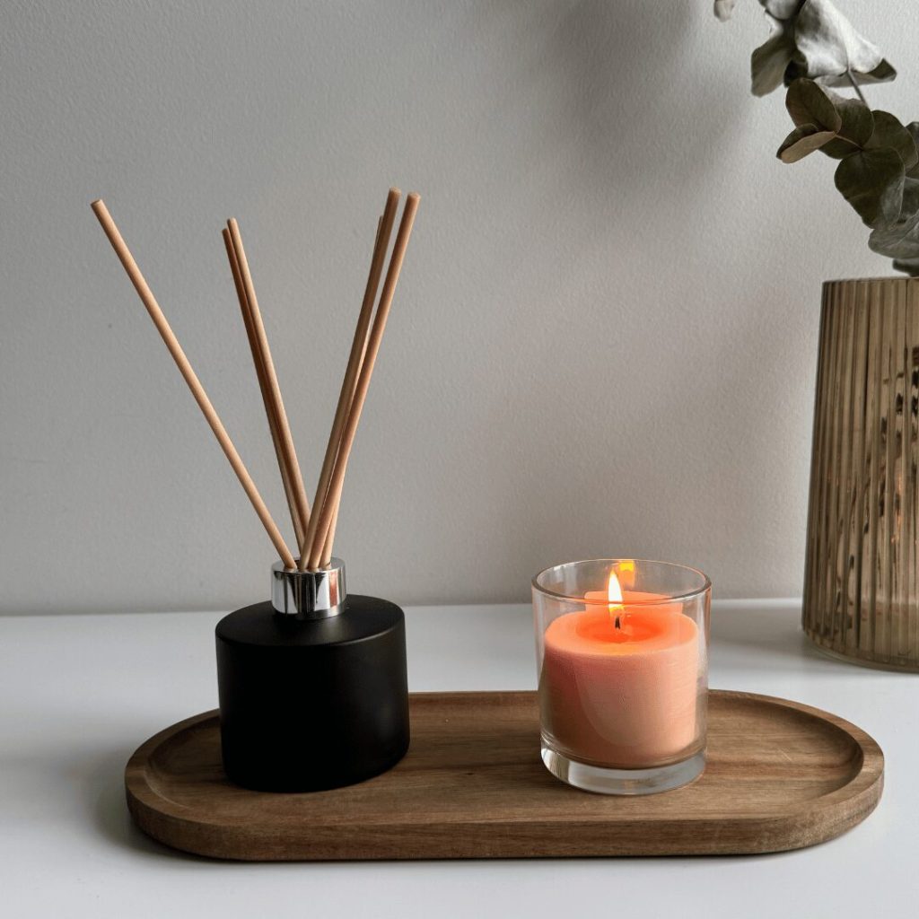 Reed diffuser and scented candle on a tray